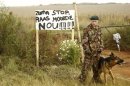 A guard stands next to a sign that reads, "Zuma, stop farm murders now!" before the funeral of Eugene Terre'blanche in Ventersdorp