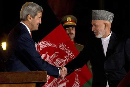 Afghanistan's President Hamid Karzai shakes hands with U.S. Secretary of State John Kerry after a news conference at the Presidential Palace in Kabul