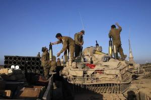 Israeli soldiers load shells onto a tank near the border &hellip;