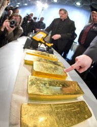 Gold ingots are on display during a press conference of Germany's Central Bank at their headquarters in Frankfurt, Wednesday Jan. 16, 2013. Germany's central bank is to bring back home some US $36 billion ( 27 billion euro) worth of gold stored in the United States and France. The Bundesbank said in a statement Wednesday that it will repatriate all 374 tons of gold it had stored in Paris by 2020. An additional 300 tons - equivalent to 8 percent of the Bundesbank's total reserves worth about US $183 billion will also be shipped from New York to Frankfurt. Frankfurt will hold half of Germany's 3,400 tons of gold by 2020, with New York retaining 37 percent and London storing 13 percent. The move follows criticism from Germany's independent Federal Auditors' Office last year bemoaning the central bank's oversight of gold reserves abroad.(AP Photo/ dpa/ Frank Rumpenhorst)