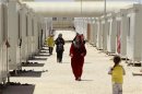 Syrian refugees walk inside the Mrajeeb Al Fhood refugee camp