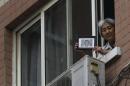 Zhang, whose son was killed by soldiers at the Tiananmen Square in 1989, holds a picture of her son after journalists were turned away, at the window of her home in Beijing