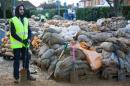A volunteer stands by with a spade as he joins others in filling sandbags to be distributed to combat flooding in Egham, west of London, on February 15, 2014