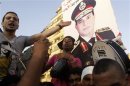 Protesters cheer with drums near a poster of army chief Abdel-Fattah El-Sisi as they gather for a mass protest to support the army in Tahrir square in Cairo