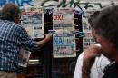 A newsagent hangs up newpapers bearing the headlines "No" and "Yes" in central Athens, on July 4, 2015, the eve of the Greek referendum on its bailout terms