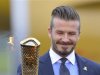 British soccer player and London 2012 Olympic Games ambassador David Beckham lights the Olympic torch with a cauldron after arriving at RNAS Culdrose base near Helston