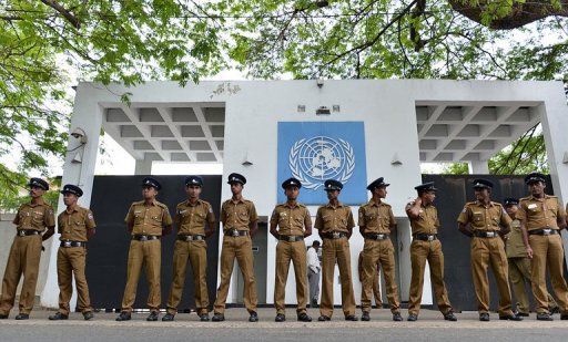 Sri Lankan police officials stand guard outside the United Nations office in Colombo on August 26, 2013