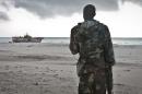 a Somali soldier looks out at a Taiwanese fishing vessel