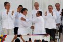 Colombian President Juan Manuel Santos (L) and Marxist rebel leader Timochenko shake hands after signing an accord ending a half-century war that killed a quarter of a million people, in Cartagena