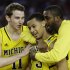 Michigan's Nik Stauskas (11), Trey Burke (3) and Corey Person celebrate after beating Kansas  87-85 in overtime of a regional semifinal game in the NCAA college basketball tournament, Friday, March 29, 2013, in Arlington, Texas. (AP Photo/David J. Phillip)