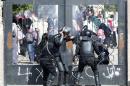 Riot police attempt to break open the entrance of the al-Azhar University Campus during clashes in Cairo