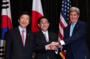 Minister of Foreign Affairs Yun Byung-se of South Korea, Minister of Foreign Affairs Fumio Kishida of Japan, and U.S. Secretary of State John Kerry join hands during a meeting between the three leaders in New York