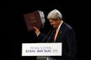 US Secretary of State John Kerry holds up the agreement at a press conference after Iran nuclear talks in Vienna on July 14, 2015