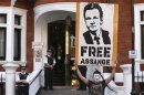 A protestor holds a poster of Wikileaks founder Julian Assange outside Ecuador's embassy in London