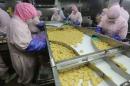 Employees work at a production line prior to a seizure at the Husi Food factory in Shanghai