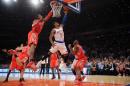 El alero de los Knicks Metta World Peace lanza a canasta ante la oposición del pívot de los Rockets Dwight Howard, en el partido disputado en Nueva York perteneciente a la jornada del jueves 14 de noviembre en la NBA