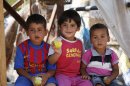 Syrian refugee children eat fruits under a tent at the Majdal Anjar refugee camp in Bekaa Valley, eastern Lebanon