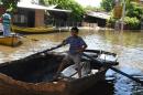 A boy uses a boat to get around a flooded neighbourhood in Asuncion on December 24, 2015