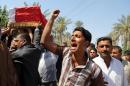Mourners chant slogans against the al-Qaida breakaway group Islamic State of Iraq and the Levant (ISIL), while carrying a flag-draped coffin of Ammar Tueni, 24, a policeman killed in a car bomb attack during his funeral procession in Hillah, about 60 miles (95 kilometers) south of Baghdad, Iraq, Thursday, April 24, 2014. The Shiite-dominated city of Hillah has seen sporadic violence recently. Last month, a suicide car bomber hit another checkpoint in same area, killing 36 people. Iraq has seen a spike in violence since last year, with the death toll climbing to its highest levels since the worst of the country's sectarian bloodletting between 2006 and 2008. The U.N. says 8,868 people were killed in 2013, and more than 1,400 people were killed in the first two months of this year. (AP Photo/Karim Kadim)