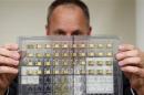 Craig Healy holds up seized radiation hardened integrated circuits in his office at the Export Enforcement Coordination Center in Northern Virginia