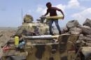 Militant loyal to Yemen's President Abd-Rabbu Mansour Hadi prepares a shell for a tank in the country's southern port city of Aden