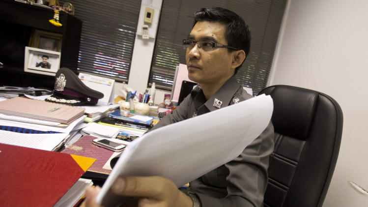 In this Aug. 26, 2014 photo, Police Col. Decha Promsuwan, an investigator in a surrogacy scandal involving a Japanese businessman, shows documents during an interview at Lumpini police station in Bangkok,Thailand. Wassana, a young Thai woman, answered an online ad offering $10,000 for surrogate mothers and is now embroiled in the case of a mysterious Japanese man, Mitsutoki Shigeta, who police say fathered at least 16 children through surrogates. The case has captivated Thailand and is at the center of a growing scandal over commercial surrogacy, an industry that thrived on semi-secrecy and legal loopholes that the country&#39;s military government now vows to ban. (AP Photo/Sakchai Lalit)