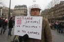 A protester holds a placard reading "Hollande out! Take care of your girlfriends" as he takes part in a demonstration in Paris, on January 26, 2014
