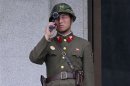A North Korean soldier looks south through a pair of binoculars on the north side of the truce village of Panmunjom in the demilitarised zone separating the two Koreas in Paju
