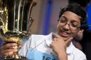 Arvind Mahankali, 13, of Bayside Hills, N.Y., holds the championship trophy after he won the National Spelling Bee by spelling the word "knaidel" correctly on Thursday, May 30, 2013, in Oxon Hill, Md. (AP Photo/Evan Vucci)