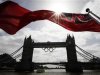 A flag on the back of a river boat flutters above Tower Bridge after the Olympic Rings were lowered into position for display in London