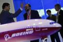 Visitors talk next to a Boeing 777X aircraft model at the Singapore Airshow