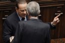 FILE - In this Friday, Nov. 18, 2011 file photo, Italy's former Premier Silvio Berlusconi, left, talks to Italian Premier Mario Monti, back to camera, at the lower chamber in Rome. Although Berlusconi resigned in disgrace a year ago, has been convicted of tax fraud and now faces plunging poll numbers, the media baron confirmed to reporters Saturday, Dec. 8, 2012, that he'll try for a fourth term. Berlusconi yanked support for Premier Mario Monti's technocrat government on Thursday, increasing the prospects for early elections. Monti calls the political crisis triggered by the loss of Berlusconi's support "manageable" and says his government has rescued Italy from financial disaster. (AP Photo/Gregorio Borgia, File)