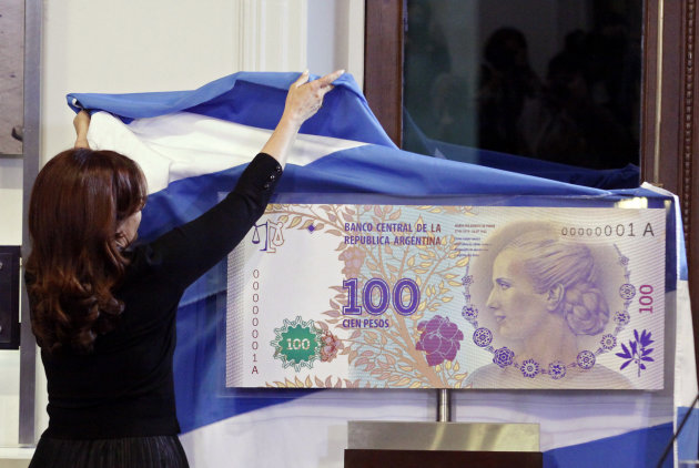FILE - In this July 25, 2012 photo, Argentina's President Cristina Fernandez unveils an archetype of the new 100 Argentine pesos bill bearing the profile of former late first lady Maria Eva Duarte de Peron, better known as "Evita," at the government palace in Buenos Aires, Argentina. Judgment day is approaching in an epic battle between Argentina and New York billionaire Paul Singer, who has sent lawyers around the globe trying to force the South American country to pay its defaulted debts. Three U.S. appellate judges will hear oral arguments in New York on Wednesday, Feb. 27, 2013, in the case, NML Capital Ltd. v. Argentina. The case has shaken bond markets, worried bankers, lawyers and diplomats, captivated financial analysts and generated enough “friend of the court” briefs to kill a small forest. (AP Photo/Alberto Raggio, DyN, File)