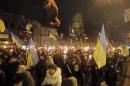 Ukrainian nationalists carry torches during a rally in downtown Kiev, Ukraine, late Wednesday, Jan. 1, 2014. The rally was organized on the occasion of the birth anniversary of Stepan Bandera, founder of a rebel army that fought against the Soviet regime. (AP Photo/Efrem Lukatsky)