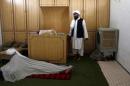 Hafiz Abdul Majid, Administrator of the Al Haaj mosque, gestures to a lectern where Taliban chief Habibullah Akhundzada taught as another cleric sleeps on the ground in Kuchlak outside Quetta