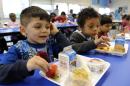 Biden Arias-Romers, 5, left, and Nathaniel Cossio-Boatwright, 6, right, eat lunch at the Patrick Henry Elementary School in Alexandria, Va., Tuesday, April 29, 2014. (AP Photo/Susan Walsh)