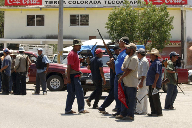 A group of armed vigilantes stand at the entrance to the town of Tierra Colorada, Mexico, Tuesday March 26, 2013. Hundreds of armed vigilantes have taken control of this town, which lies on a major highway in the Pacific coast state of Guerrero, arresting local police officers and searching homes after one of their vigilante leaders was killed. (AP Photo/Alejandrino Gonzalez)