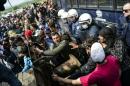 Refugees and migrants attempt to break through a barricade held by Greek police as they protest in Idomeni, on April 11, 2016