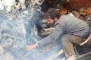 A man inspects the wreckage of a Syrian warplane that was shot down in the Talat al-Iss area, south of Aleppo