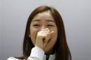 South Korean figure skater Kim Yuna smiles during a news conference ahead of Sochi 2014 Winter Olympics, in Seoul