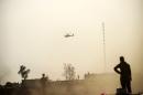A helicopter prowls the perimeter of the Qayyarah military base, about 35 miles south of Mosul in Iraq on October 18, 2016 during an operation by Iraqi government forces-lead and US-supported efforts to retake the city from the Islamic State