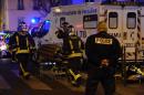 Firefighters evacuate an injured person near the Bataclan concert hall in central Paris, on November 14, 2015