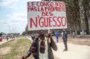 A man holds a sign reading "Congo is not the property of N'Guesso" during an opposition demonstration in Brazzaville on September 27, 2015