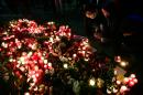 People light candles at a makeshift memorial in front of the Kaiser-Wilhelm-Gedaechtniskirche in Berlin, where a truck crashed the day before into a Christmas market