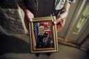 Wilburn Russell displays a portrait of his son, the Army sergeant who is accused of killing five fellow soldiers in Iraq, in Sherman