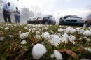 Golfball sized hail litter the ground by Andrew Stamps and his wife Valorie as they prepare to cover their shattered rear window of her 2009 Toyota Avalon in Pearl, Miss., Monday, March 18, 2013, following a hailstorm that hit communities throughout central Mississippi. The National Weather Service in Jackson says there were a few super cells in central Mississippi and reports of hail up to baseball size in Clinton, golf ball and tennis ball sized in Pearl and Brandon and quarter sized in downtown Jackson, Miss. The Mississippi Emergency Management Agency says severe weather has caused damage in at least 10 counties as the storms moved through parts of the state. (AP Photo/Rogelio V. Solis)