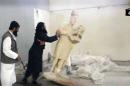 An IS militant knocks over a statue inside the Mosul museum in northern Iraq, on February 25, 2015