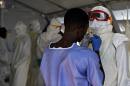 Health workers put on protective equipment at an Ebola treatment centre in Kenama, Sierra Leone, on November 15, 2014