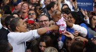 U.S. President Barack Obama (L) is handed a baby as he greets supporters after a campaign rally at Elm Street Middle School in Nashua, New Hampshire, October 27, 2012. REUTERS/Jonathan Ernst