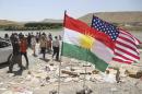 U.S. and Kurdish flags flutter in the wind